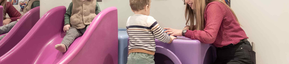 Une pro en crèche jouant avec deux enfants 