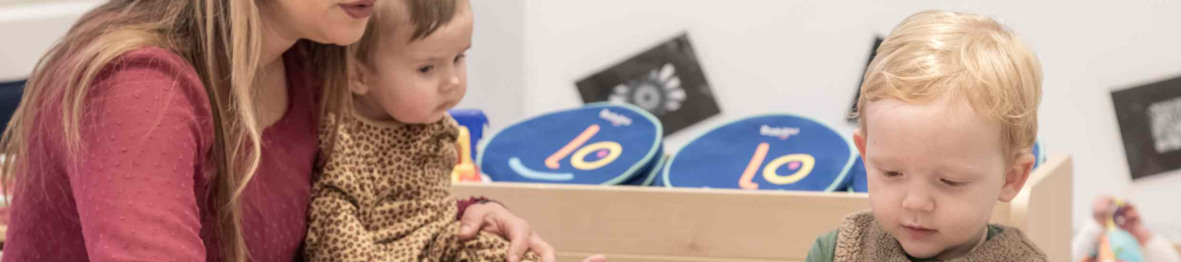 Une pro en crèche en interaction avec deux enfants 