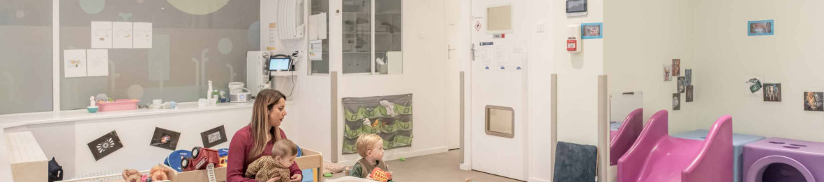 Une pro en crèche dans l'espace de jeu avec les enfants 