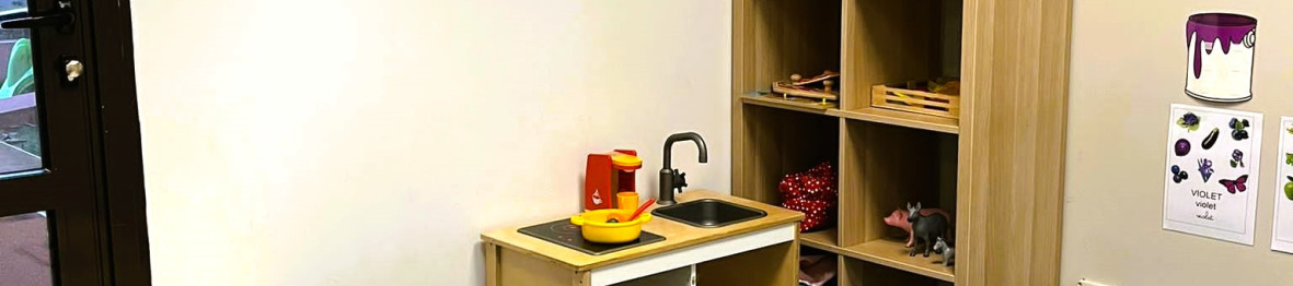 Grand pièce avec jouets et une table dans la crèche Babilou Montpellier Club 7