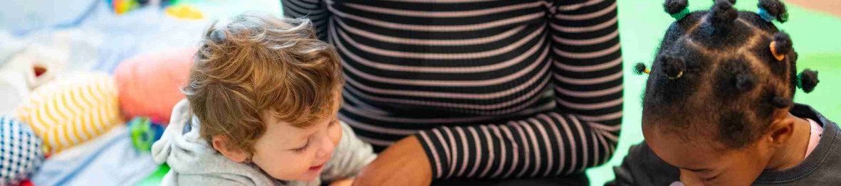 Une pro en crèche qui lit un livre à des enfants