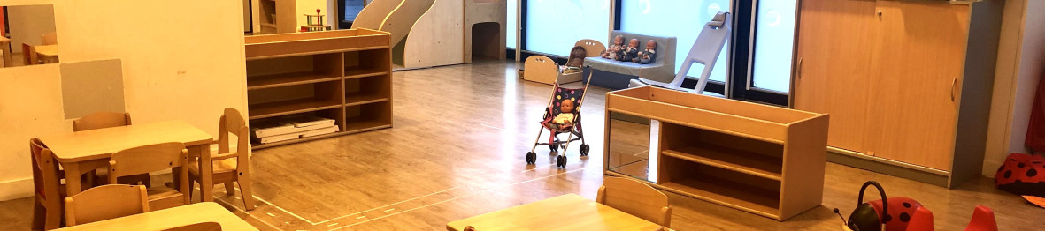 Salle d'éveil avec tables et tabourets au sein de la crèche Babilou Grenoble Schuman