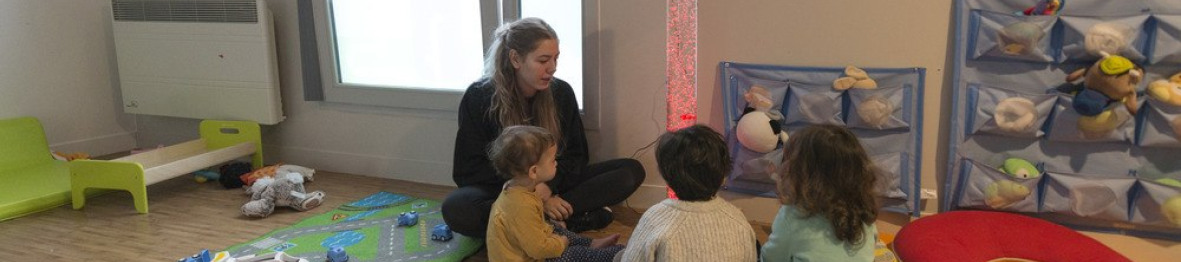 Une pro en crèche en interaction avec un groupe d'enfants 