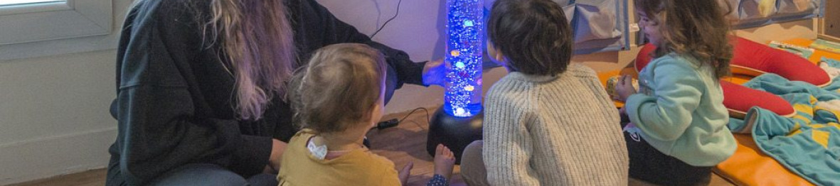 Une pro en crèche en interaction avec un groupe d'enfants 