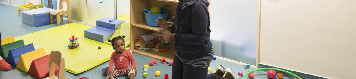 Une professionnelle en crèche qui joue avec une enfant