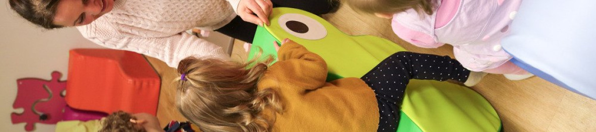 Une professionnelle en crèche jouant avec deux enfants