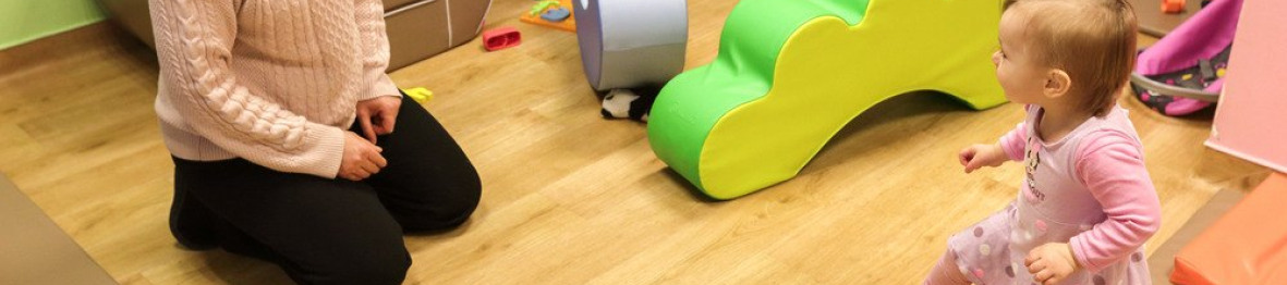 Une professionnelle en crèche qui joue avec deux enfants