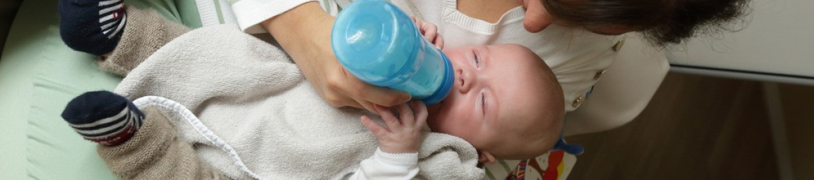Une pro en crèche donnant le biberon à un bébé