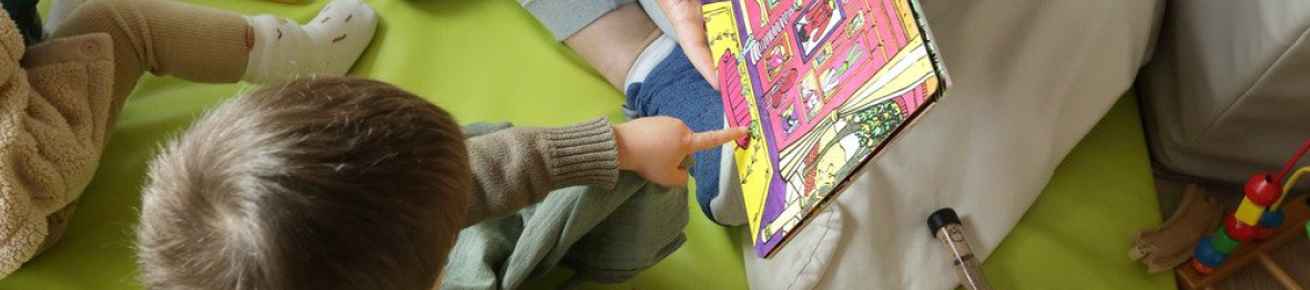 Une pro en crèche qui lit un livre à un enfant