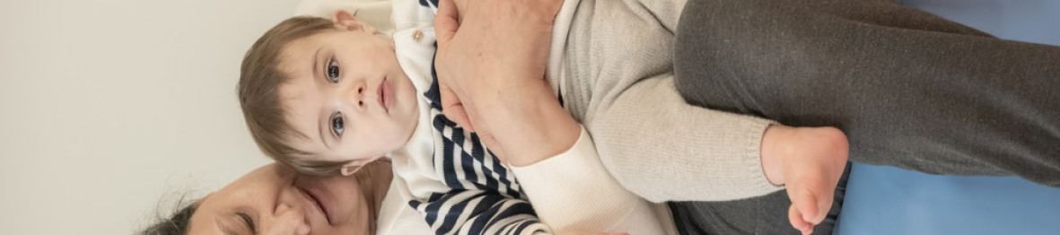 Une pro en crèche assise avec un enfant