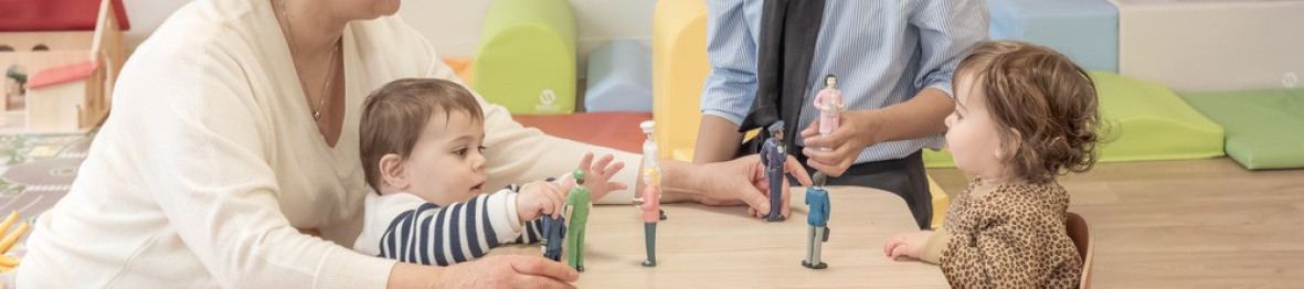 Deux pro crèche qui jouent avec deux enfants 