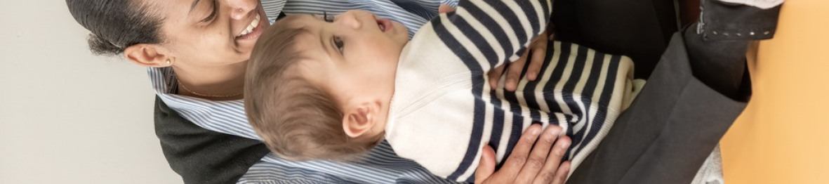 Une pro en crèche assise avec un enfant