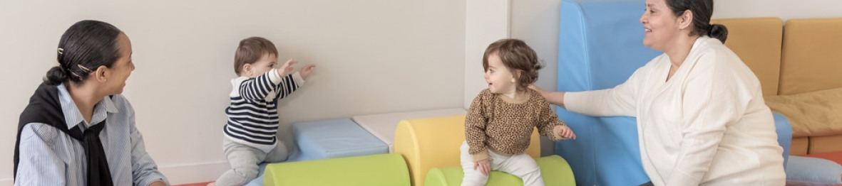 Deux pro crèche qui jouent avec deux enfants 