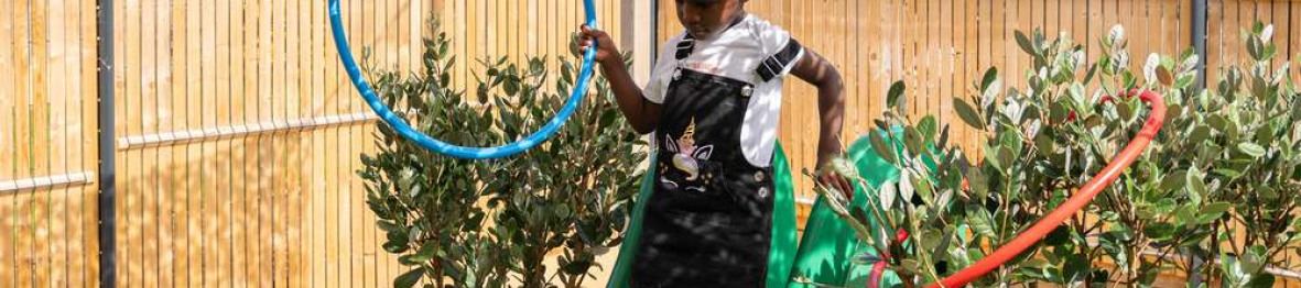 Une petite fille en crèche qui joue dans le jardin