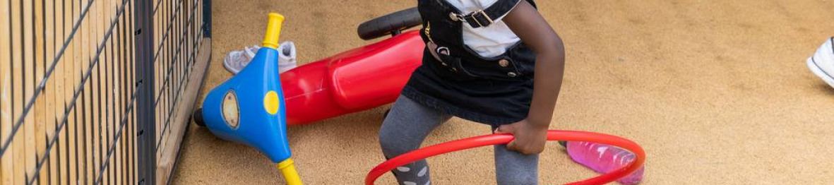 Une petite fille en crèche qui joue dans le jardin