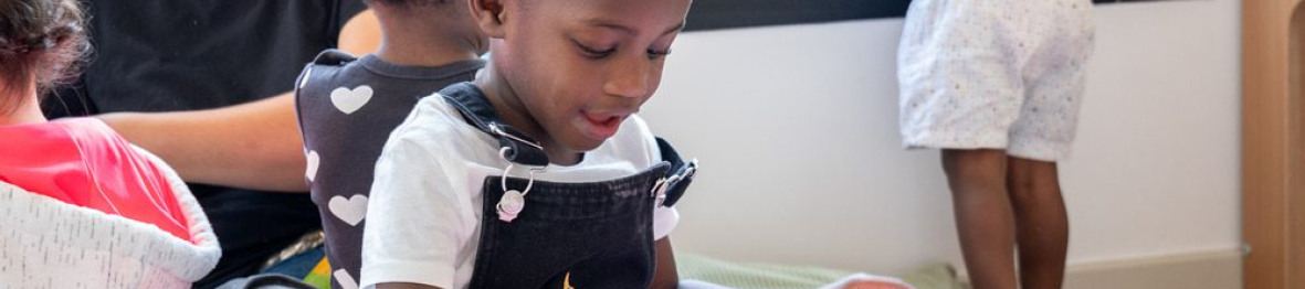 Une petite fille en crèche qui regarde un livre