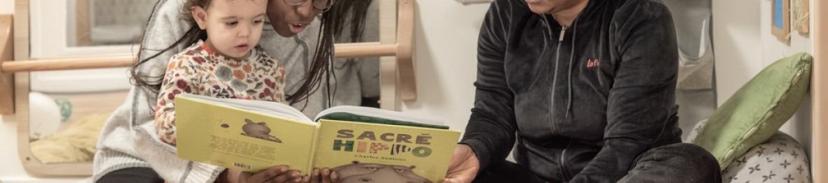 Deux pro en crèche avec un enfant lisant un livre