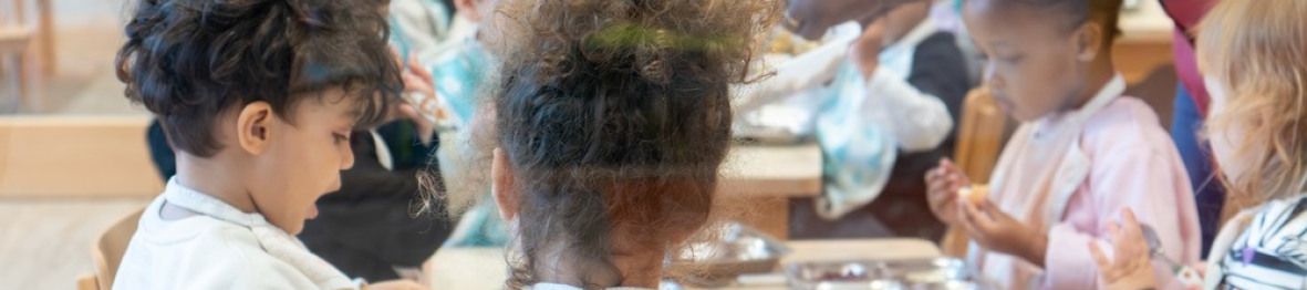 Un groupe d'enfants en crèche qui mangent 
