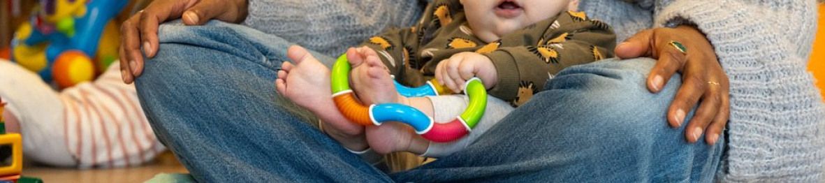 Une pro en crèche assise avec un bébé