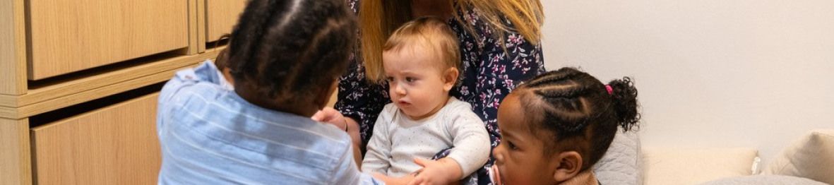 Une pro en crèche jouant avec trois enfants 