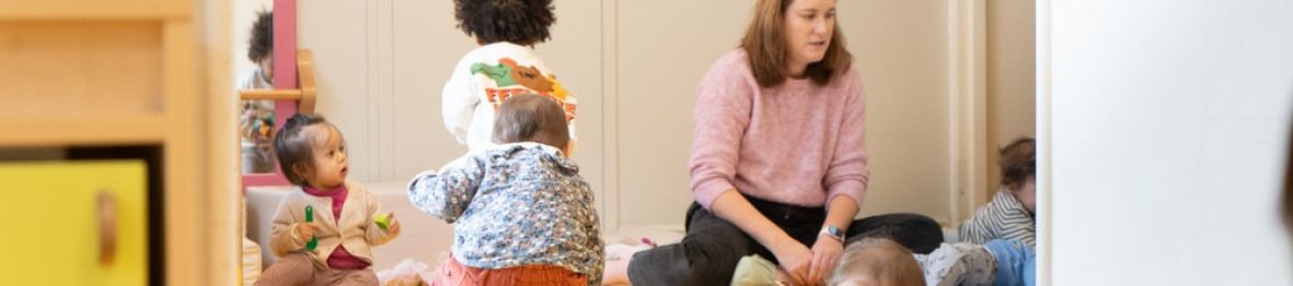 Une pro en crèche en interaction avec un groupe d'enfants
