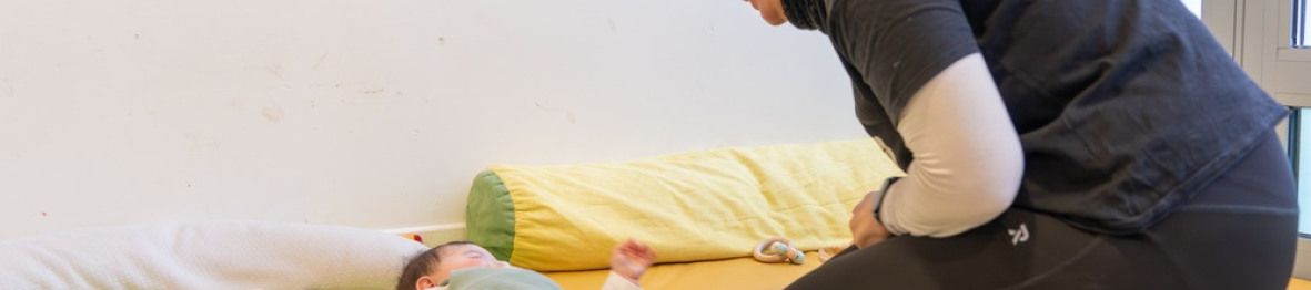 Une pro en crèche en interaction avec un bébé