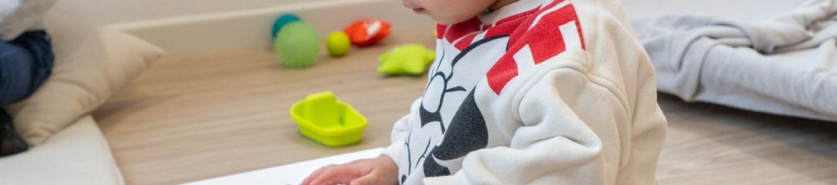 Un enfant en crèche Babilou qui regarde un livre 