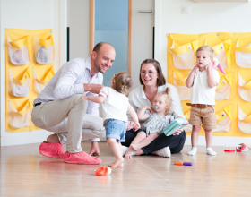 Un parent, une professionnelle et des enfants discutent en crèche Babilou