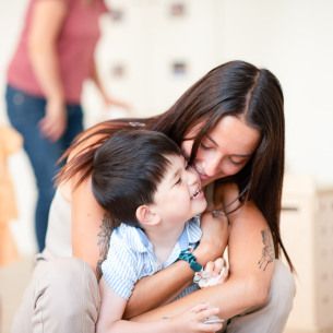 Une professionnelle de crèche fait un câlin à un enfant