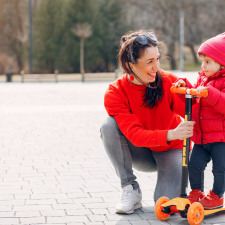 Une femme avec sa fille sur une trottinette à 3 roues