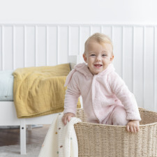 Un bébé souriant dans un bac en bois 