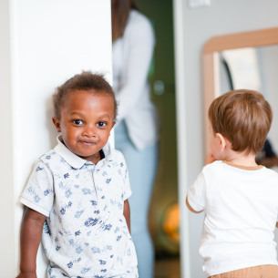 Enfant en crèche, au milieu d'un autre groupe d'enfants