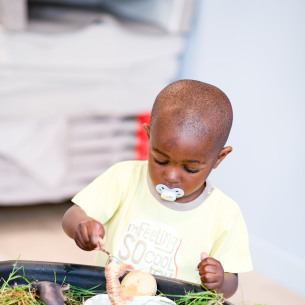 Enfant en crèche Babilou en activité nature sensorielle