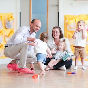 Un papa et son enfant, avec un professionnel de crèche en crèche