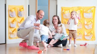 Un parent, une professionnelle et des enfants discutent en crèche Babilou