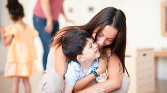 Une professionnelle de crèche fait un câlin à un enfant