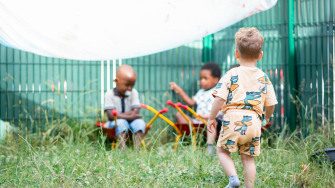 Trois enfants en train de jouer dans le jardin d'une crèche Babilou